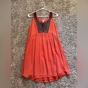 Orange Sleeveless Sundress with Black, red, and blue Detailing.